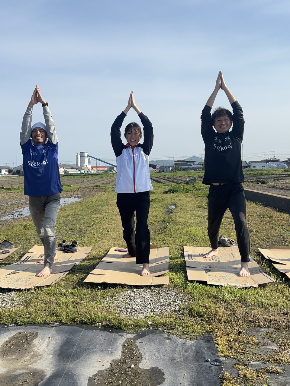 田んぼの前でヨガ体験を楽しむ参加者たち
